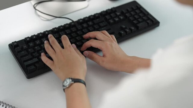 Employee typing on a computer keyboard and working in the office, female hands programming and writing code on a desktop personal computer, business person data entry