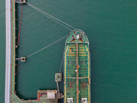 Aerial view of a large tanker ship docked at a pier in the sea, Cilacap, Central Java, Indonesia.