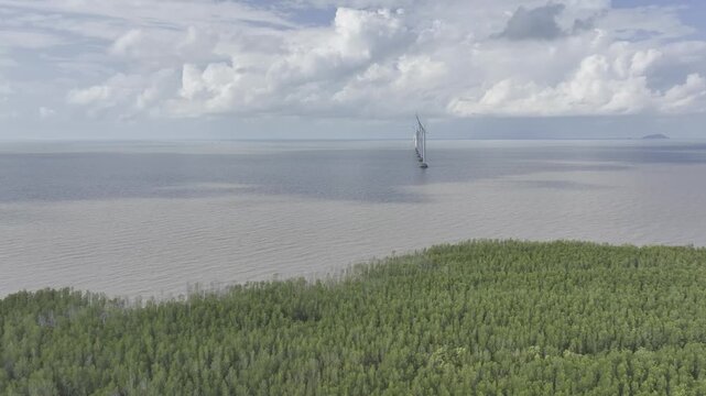 Aerial drone view of Mui Ca Mau National Park in Dat Mui, Ca Mau, Vietnam, featuring the national flagpole and coordinate marker surrounded by sunlit mangrove forests.