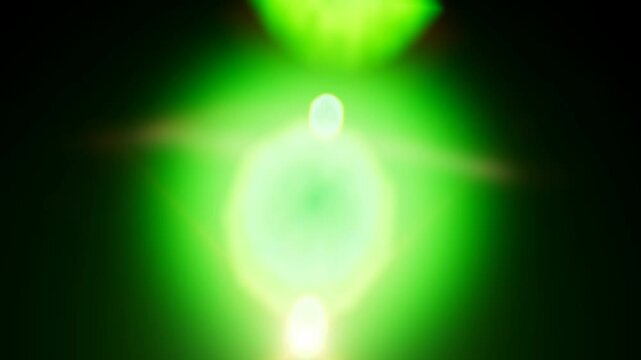 Vibrant green circular lens flare effects on black background in 4k render