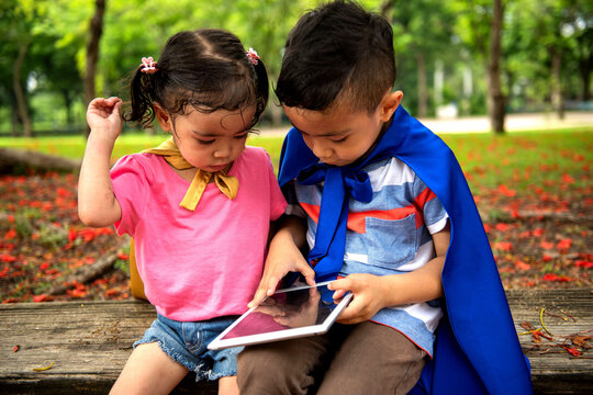 Children exploring digital tablet outdoors
