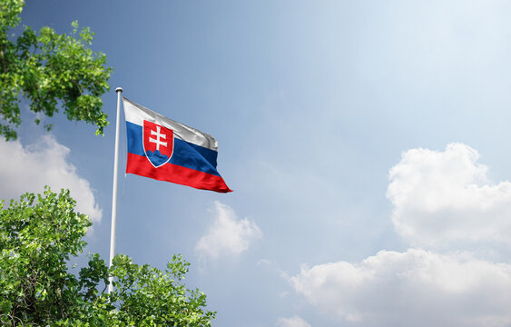 Slovakia national flag waving in the sky behind the tree. The flag waving in the sky. Slovakia national flag for independence day.