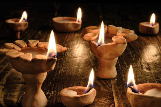 Handmade clay diyas with glowing flames for Diwali celebration