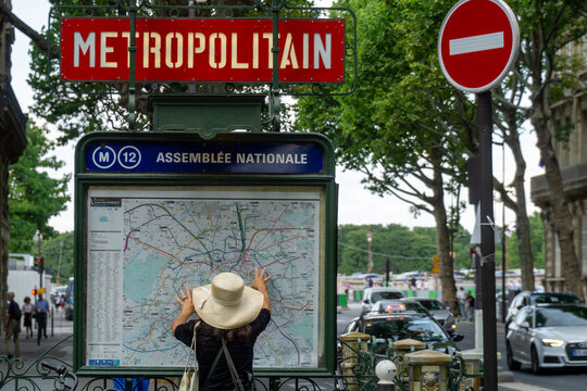Paris, France - July 13, 2019: Woman studying Paris Metro subway map at Assembl&eacute;e Nationale station