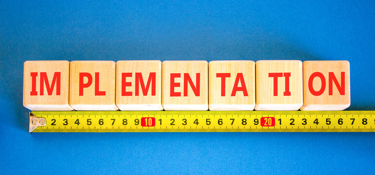 Implementation word symbol. Concept word Implementation on beautiful wooden blocks. Beautiful blue background. Beautiful yellow ruler. Business implementation word concept. Copy space.