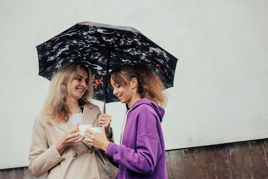 Two sisters spending time together drinking coffee and walking in autumn