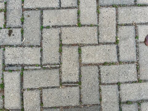 Top View of Grey Concrete Interlocking Paving Block Footpath with Herringbone Pattern Texture Background