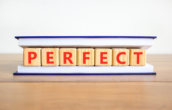 Perfect word symbol. Concept word Perfect on beautiful wooden blocks in book. Beautiful wooden table white background. Business perfect word concept. Copy space.