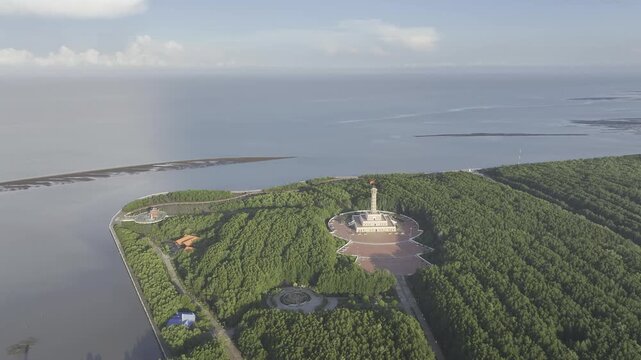 Aerial drone view of Mui Ca Mau National Park in Dat Mui, Ca Mau, Vietnam, featuring the national flagpole and coordinate marker surrounded by sunlit mangrove forests.