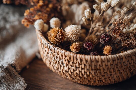 Handwoven rattan basket filled with dried flowers, styled in warm earthy shades for a rustic natural look