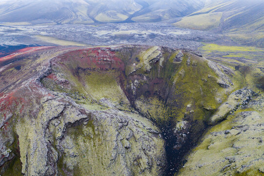 Aerial view of Fjallabak Nature Reserve featuring a volcanic crater with vibrant moss-covered slopes, rugged lava formations, and dramatic geological textures in Rangarthing ytra, Iceland.