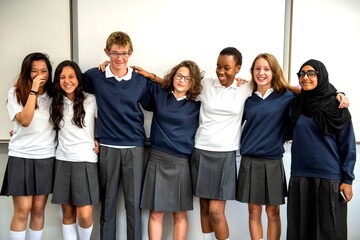Fototapeta premium Group of diverse students in school uniforms smiling together.