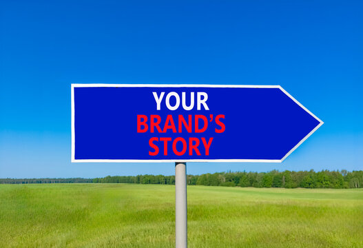 Branding and your brands story symbol. Concept words Your brands story on beautiful blue road sign. Beautiful blue sky green grass background. Business branding your brands story concept. Copy space