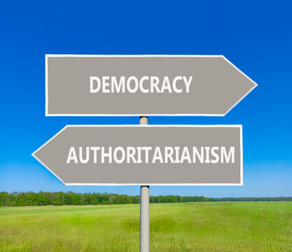 Democracy or authoritarianism symbol. Concept words Democracy Authoritarianism on beautiful grey road sign. Beautiful blue sky background. Business democracy authoritarianism concept. Copy space