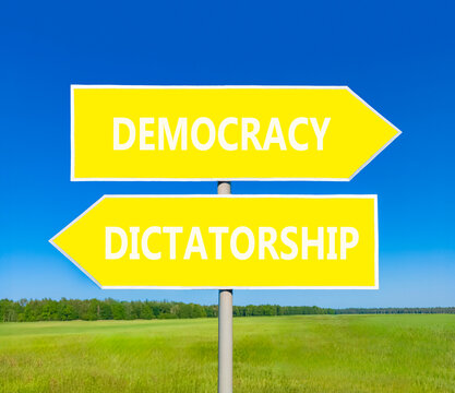 Democracy or dictatorship words symbol. Concept words Democracy Dictatorship on beautiful yellow road sign. Beautiful blue sky background. Business democracy dictatorship concept. Copy space