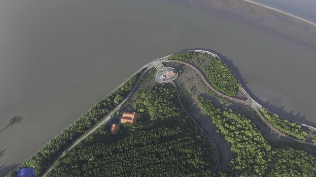Aerial drone view of Mui Ca Mau National Park in Dat Mui, Ca Mau, Vietnam, featuring the national flagpole and coordinate marker surrounded by sunlit mangrove forests.