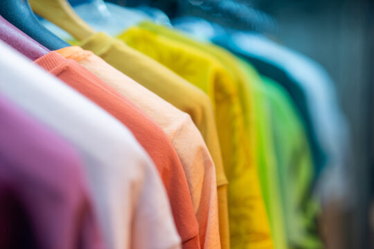 Rainbow Row of Vibrant T-Shirts on Rack with Bokeh