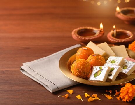 Traditional Diwali mithai sweets with glowing diyas