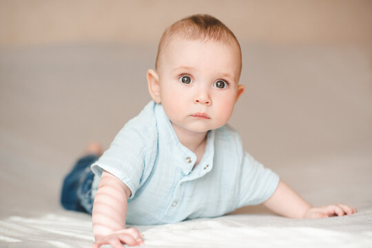 Cute baby boy crawling in bed close up. Good morning. Babyhood.