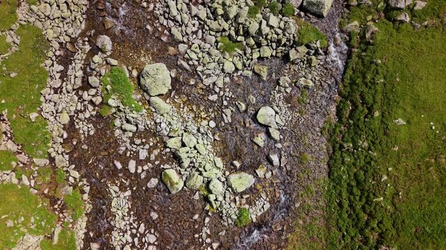 Mountain stream flowing over rocky riverbed from above