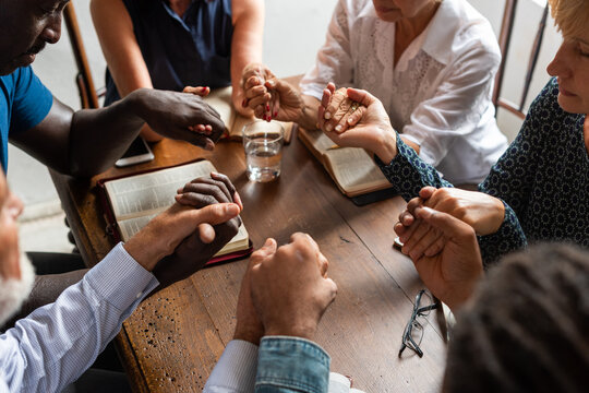 Diverse group holding hands prayer