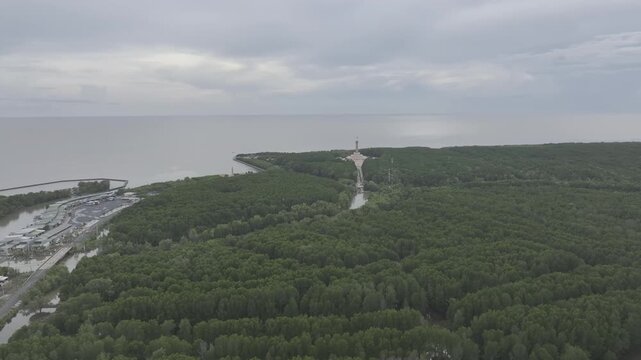 Aerial drone view of Mui Ca Mau National Park in Dat Mui, Ca Mau, Vietnam, featuring the national flagpole and coordinate marker surrounded by sunlit mangrove forests.