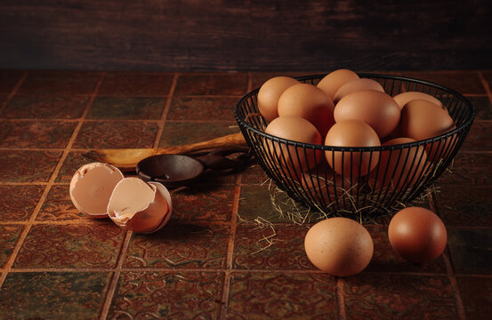 Fresh brown eggs in a basket ready for baking and cooking on a rustic tiled surface