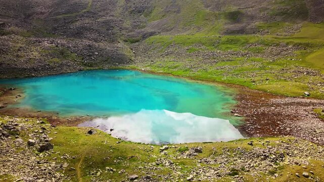 High-angle aerial view of a turquoise alpine mountain lake