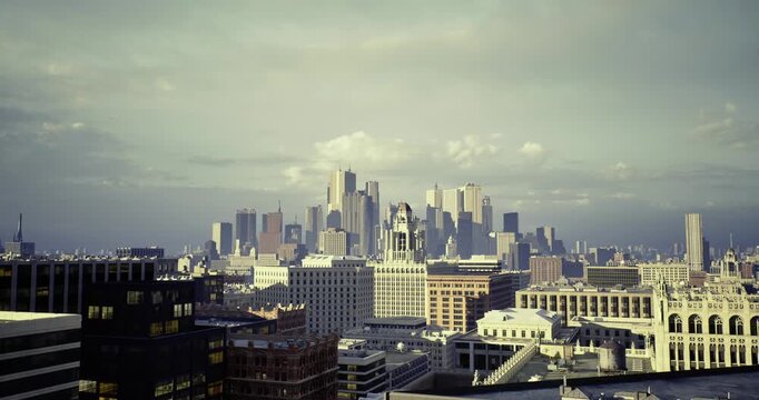 city skyline at hazy dawn showcasing rooftops and distant towers, moody light casting long shadows across concrete facades, grainy film tone evoking urban