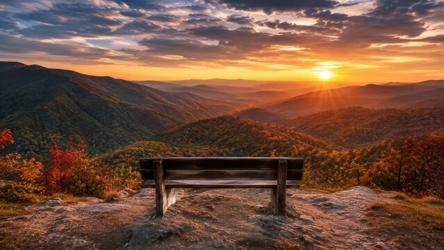 Scenic mountain overlook with wooden bench facing dramatic sunset across rolling valley landscape and distant peaks