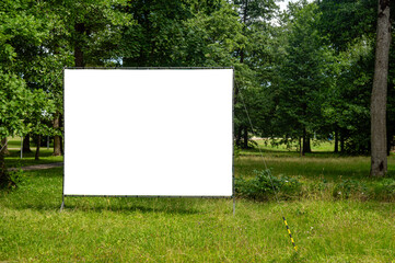 Fototapeta premium Billboard mockup template in a green park under a clear sky
