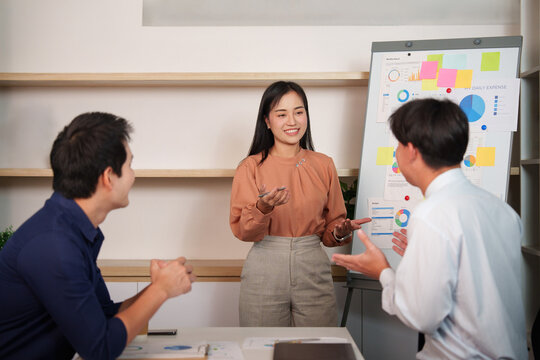 Diverse Asian business team collaborating on corporate strategy presentation