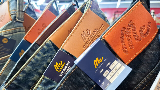 Mc Jeans brand denim pants with leather logo patches and paper tags displayed in fashion retail store on July 27, 2026 in Bangkok, Thailand