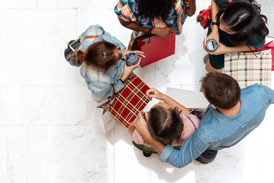 Overhead view of diverse young shoppers carrying gifts in a mall