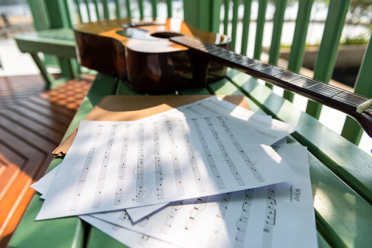 Guitar with sheet music outdoors.
