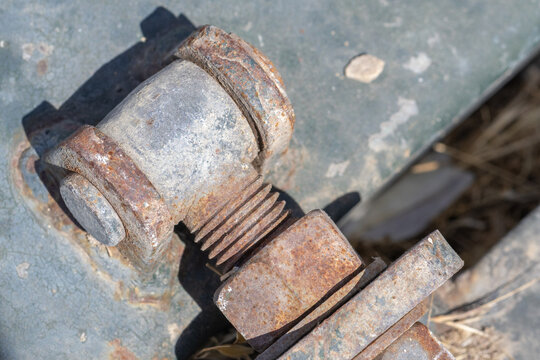 Rusted metal bolt and nut on weathered surface