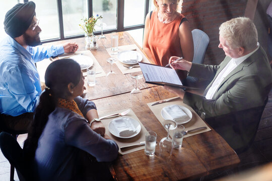 Business meeting in restaurant setting.