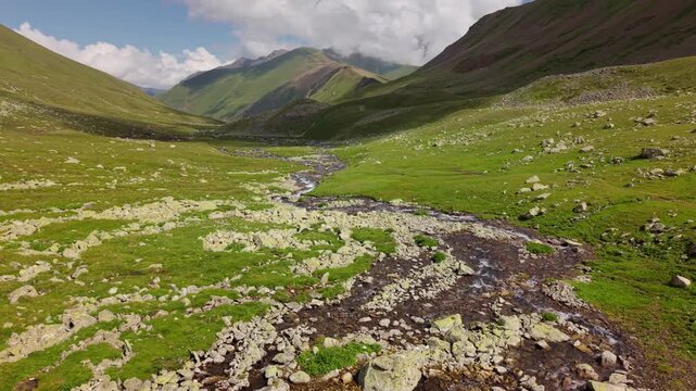 Aerial view of a mountain river flowing through a green valley