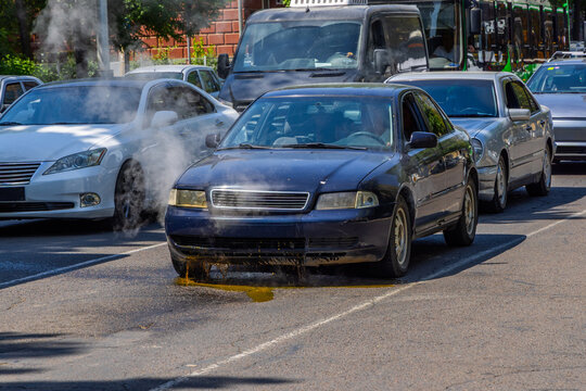 Car with Radiator Failure Leaking Coolant and Emitting Steam in Traffic