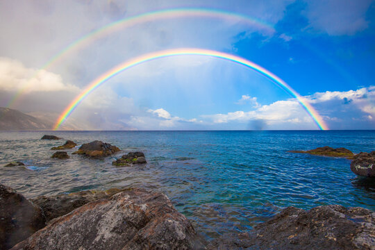 Full double rainbow over rocky coastline and blue sea, Paleochora, Crete, Greece