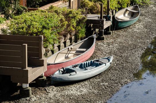 Venice Los Angeles California canals with colorful kayaks and canoes beside wooden docks, lush gardens, waterfront homes and calm water