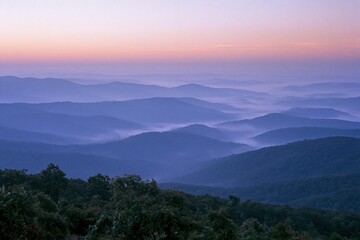 Fototapeta premium The Mountain Range at Sunrise Over Misty Ridges and Quiet Valley Horizons