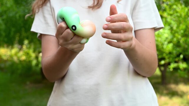 Girl squeezing colorful dumpling-shaped squishy toys