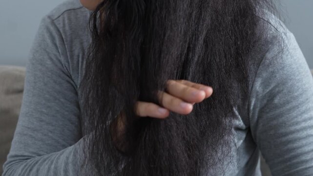 woman sticking brushing her hair falling out and have many hair loss on the comb. problem of Damaged and frizzy. Healthcare and medical concept.	
