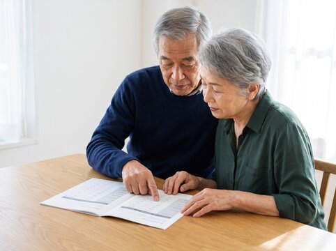 Older couple reviewing paperwork together at a table in a bright home interior