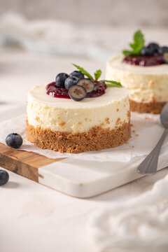 Mini cheesecakes with blueberry topping on a wooden board
