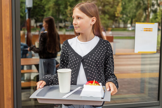 Girl Carrying Food Tray with Fries and Drink at Cafe