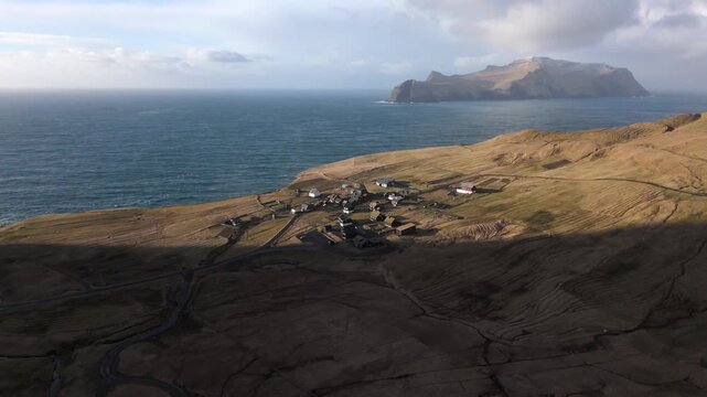フェロー諸島の断崖に佇む小さな village と大西洋、空撮（Faroe Islands Coastal Village Aerial 4K）