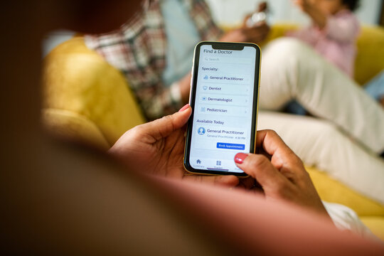 Person booking a doctor appointment on smartphone at home