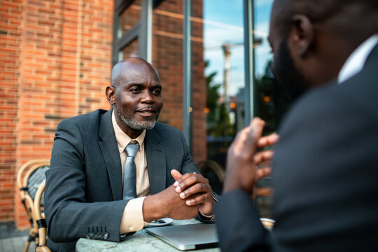 Two business professionals meeting at outdoor cafe